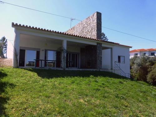 a small white house on a hill with a yard at Casa do Bode in Levegada