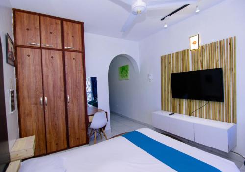 um quarto com uma cama e uma televisão de ecrã plano em Mombasa bamburi staycation 2 em Mombaça