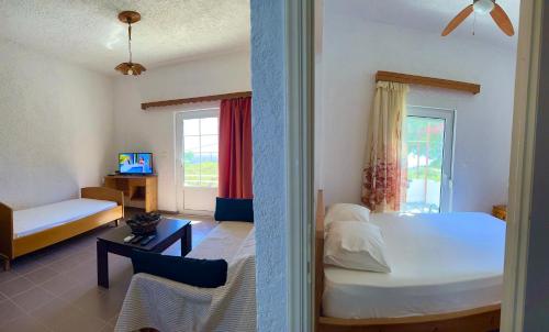 a bedroom with a bed and a couch and a table at Studios Crete in Ferma