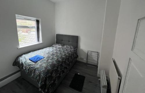 a bedroom with a bed with a blue pillow on it at Snugly Studio Flat near Talbot Pub in Birmingham