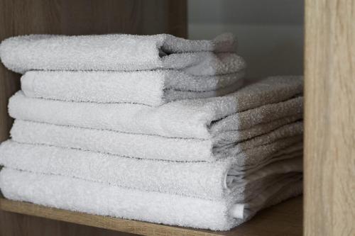 a stack of white towels sitting on a shelf at Sea View in Adelianos Kampos