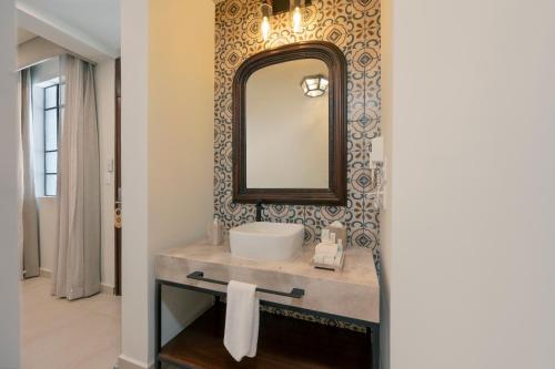 a bathroom with a sink and a mirror on a wall at Gran Hotel Mexico by Solaris in Tehuacán