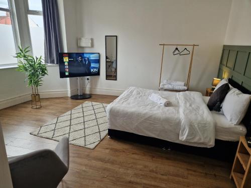 a bedroom with a bed and a flat screen tv at West Beck House - Newcastle 3 in North Shields