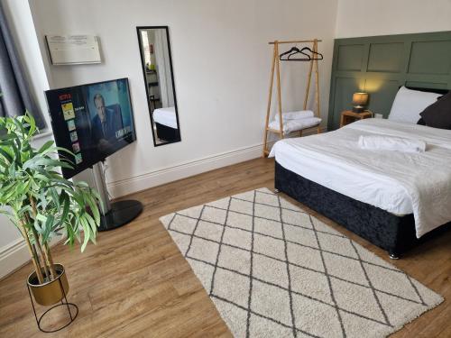 a bedroom with a bed and a flat screen tv at West Beck House Newcastle - Spacious Double Room in North Shields