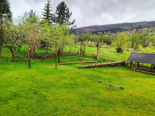 a park with a bench in a grass field at Chata Pod Kwiatkiem in Zawoja