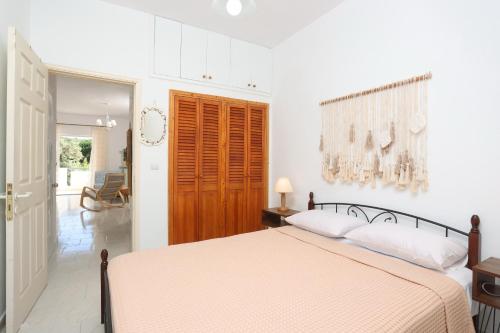 a white bedroom with a bed and a hallway at Bohemian Dreamscape #PROPERTLY in Hanioti