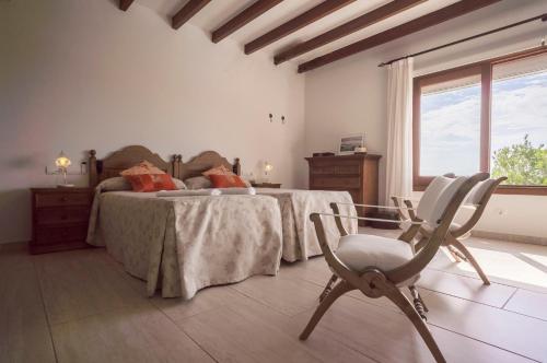 two beds in a room with a chair and a window at AZUMAR in Santa Eularia des Riu