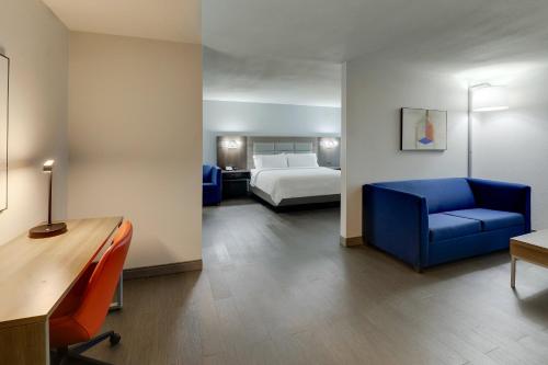 um quarto de hotel com uma cama e uma cadeira azul em Holiday Inn Express Lexington Southwest Nicholasville, an IHG Hotel em Nicholasville