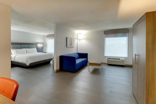 a hotel room with a bed and a blue chair at Holiday Inn Express Lexington Southwest Nicholasville by IHG in Nicholasville