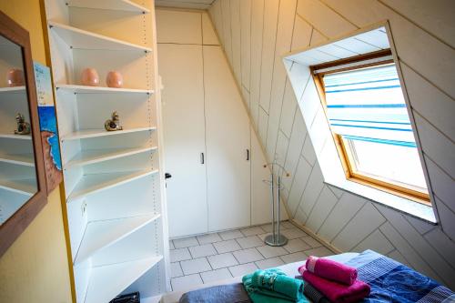a small bathroom with white shelves and a window at Schönes Studio in der Rheinebene, zentral gelegen in Rheinstetten