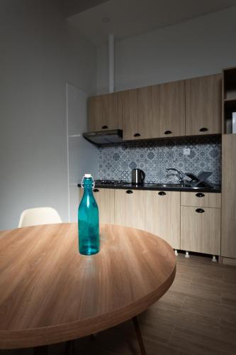 a blue bottle sitting on a wooden table in a kitchen at O Sobrado Mariazinha & Inácio Lima in Praia