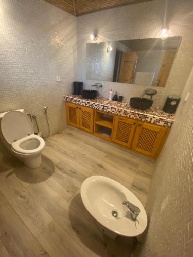 a bathroom with a white toilet and a sink at Magnifica villa con giardino e piscina in Nianing
