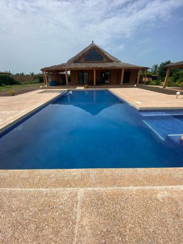 a blue swimming pool in front of a house at Magnifica villa con giardino e piscina in Nianing