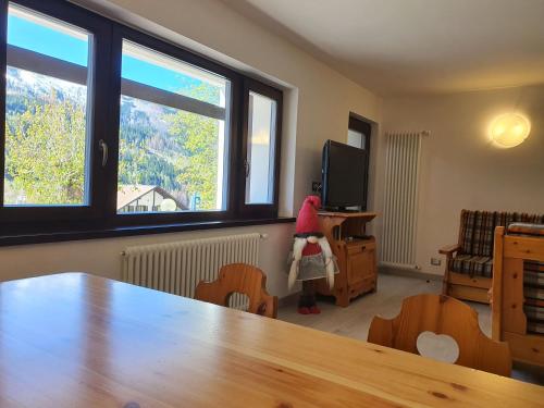 Cette chambre dispose d'une table, d'une télévision et de 2 fenêtres. dans l'établissement Il Rifugio dello Gnomo - Alpine Stay Apartments, à Panchià