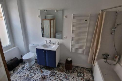 une salle de bain avec un lavabo, des toilettes et un miroir dans l'établissement Le pty clo de Mag, à Lussac-les-Églises
