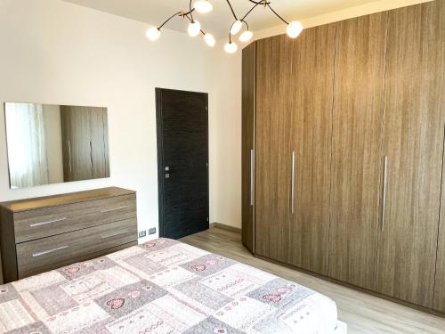 a bedroom with a bed and a dresser and a mirror at Due Pini Apartment - Ponte Caffaro Lake Idro in Ponte Caffaro
