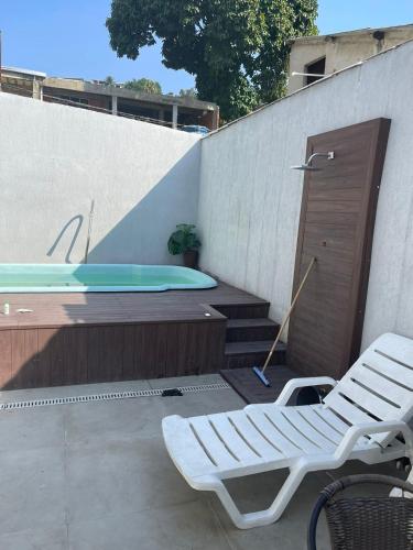 a patio with a pool and a chair and a tub at Mansão do Imperador in Duque de Caxias