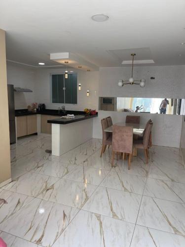 a kitchen and dining room with a marble floor at Mansão do Imperador in Duque de Caxias