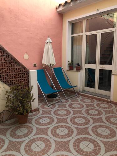 a patio with a chair and an umbrella on a floor at Traditional Sardinian house in San Vito