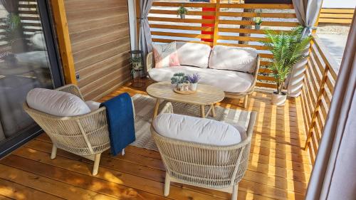 a porch with chairs and a table and a couch at Mobile Homes Jaki - 2 Bathrooms, Large Terrace in Biograd na Moru