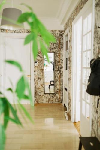 Cette chambre dispose d'un couloir avec un miroir et une plante. dans l'établissement Grand appartement familial de prestige coeur de Lyon, à Lyon