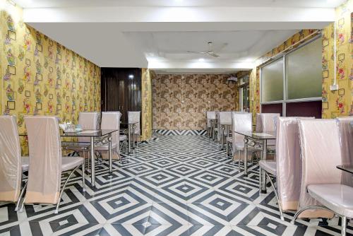 uma sala de jantar com mesas e cadeiras num piso estampado em Hotel Trishiv em kolkata