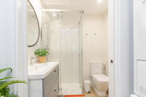 a white bathroom with a shower and a toilet at Carretes 1 in Barcelona
