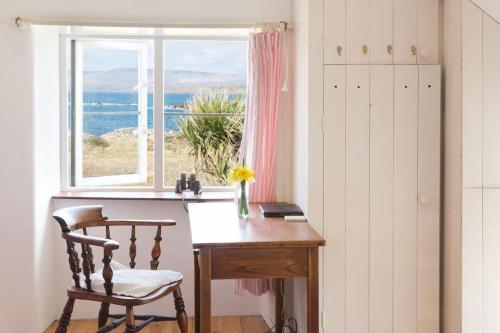a desk with a chair in front of a window at Shore Cottage on the Beara Way Wild Atlantic Way in Eyeries