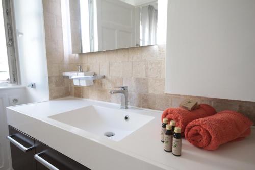 une salle de bain avec un lavabo, un miroir et des serviettes dans l'établissement Spacieux 2 Pièces Montmartre, à Paris