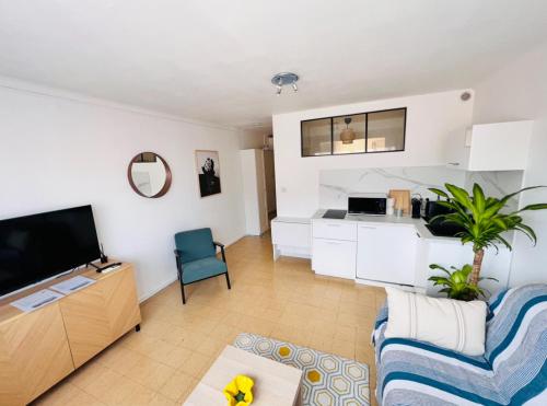 un salon avec un canapé et une télévision dans l'établissement 2 pièces, 8mn à pied de la croisette/plage, à Cannes