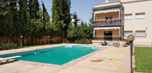 een zwembad voor een huis bij VILLA PLAISANCE in Meknès