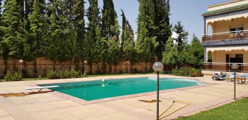 een zwembad in een tuin naast een huis bij VILLA PLAISANCE in Meknès