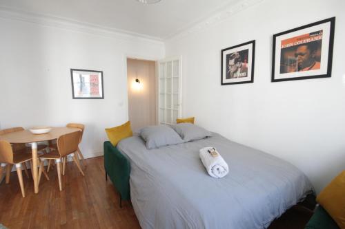 une chambre avec un lit avec une serviette dessus dans l'établissement Spacieux 2 Pièces Montmartre, à Paris