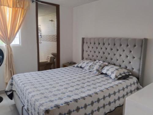 a bedroom with a bed with a quilt on it at 3 NOCHES MINIMAS ESTADIA APARTAMENTO 4 PERSONAS AIRE ACONDICIONADO-buena ubicación in Valledupar