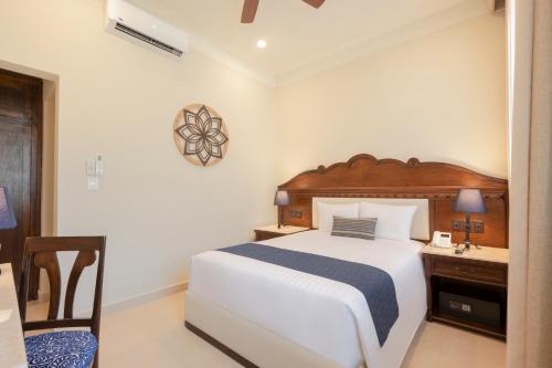 a bedroom with a bed and a desk and a clock at Gran Hotel Mexico by Solaris in Tehuacán