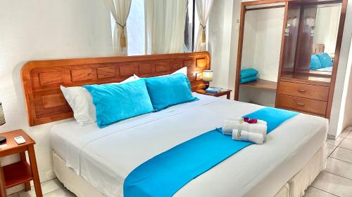 a bedroom with a large bed with blue pillows at Hostal Sueños Silvestres in Puerto Ayora