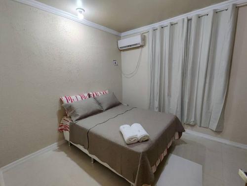 Cette petite chambre comprend un lit et 2 serviettes. dans l'établissement CasaCozy, à Boa Vista