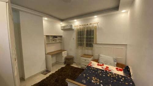 - une petite chambre avec un lit et un bureau dans l'établissement شقة فندقية للإيجار في زهراء المعادي, au Caire
