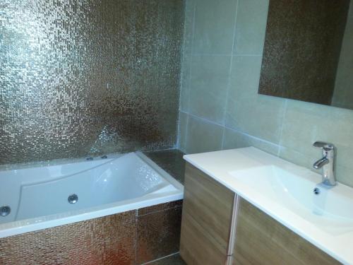 La salle de bains est pourvue d'une baignoire et d'un lavabo. dans l'établissement LE GRANd BLEU - ONLY FAMILIES, à Sidi Bouqnadel