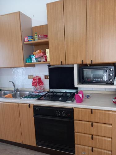 a kitchen with a stove and a microwave at Casa turistica Santa Lucia 25 in Regalbuto
