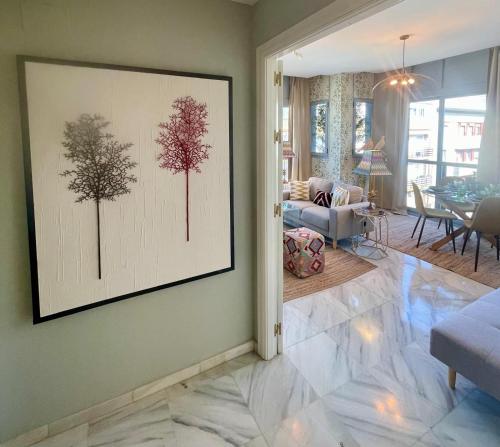 a living room with a painting of trees on the wall at Apartamento Virgen de la Victoria in Seville