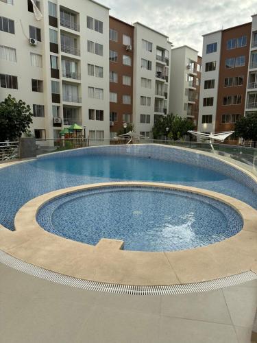 una gran piscina frente a algunos edificios en Exclusivo departamento en condominio con Piscina en Piura