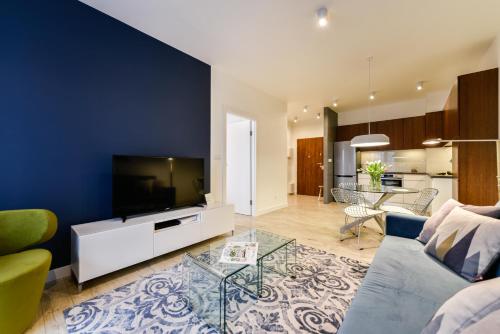 a living room with a couch and a tv at Apartamenty Tespis - Francuska Atal Park in Katowice