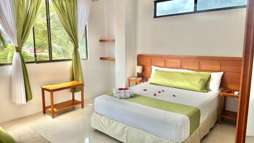 1 dormitorio con 1 cama con sábanas verdes y blancas en Hostal Sueños Silvestres, en Puerto Ayora