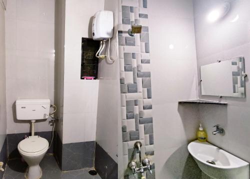 a small bathroom with a toilet and a sink at Ambient Homestay by NESTEASY in Nashik