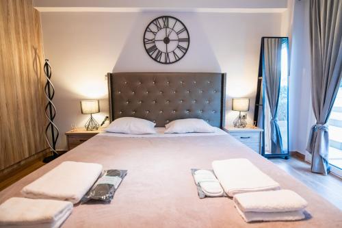 1 dormitorio con 1 cama grande y reloj grande en la pared en Lux Modern Apt Ανακαινισμένο διαμέρισμα 150m από την πλαζ 'ΈΔΕΜ', en Atenas
