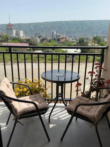 eine Terrasse mit einem Tisch und 2 Stühlen auf einem Balkon in der Unterkunft Annia Apartament in Tbilisi City