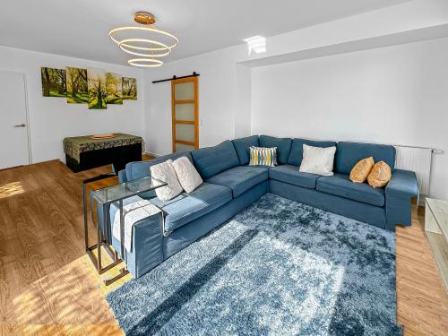 un salon avec un canapé bleu et un tapis dans l'établissement Calme et Confort aux Portes de Paris, à Bezons