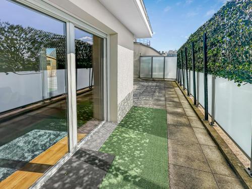 un balcon vide d'une maison avec des portes en verre dans l'établissement Calme et Confort aux Portes de Paris, à Bezons