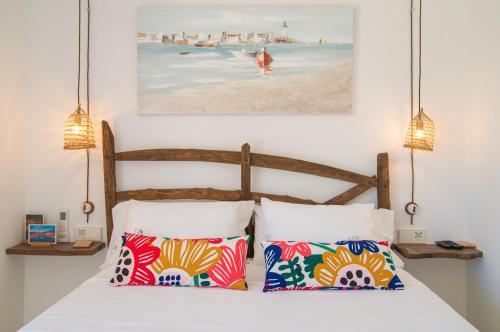 um quarto com uma cama com duas almofadas e um quadro em Acogedor Duplex en Ciutadella-Playa Santandria em Cala Santandria